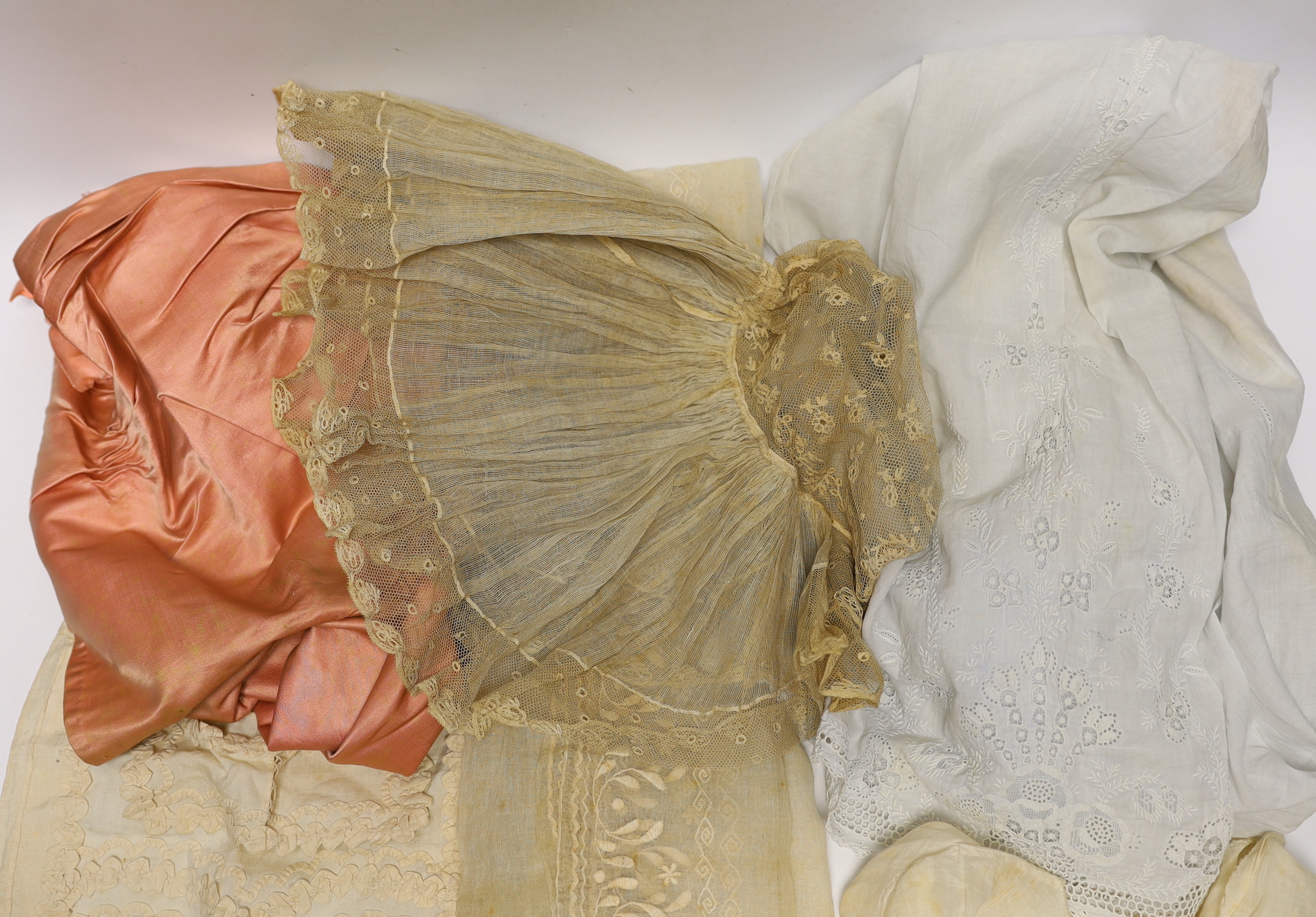 An 18th century Dresden worked apron, a white worked fine lawn stole, two panels of linen ribbon work, a ladies lace bonnet a similar pink satin bonnet a white worked blouse (partially made) and panel to a christening go